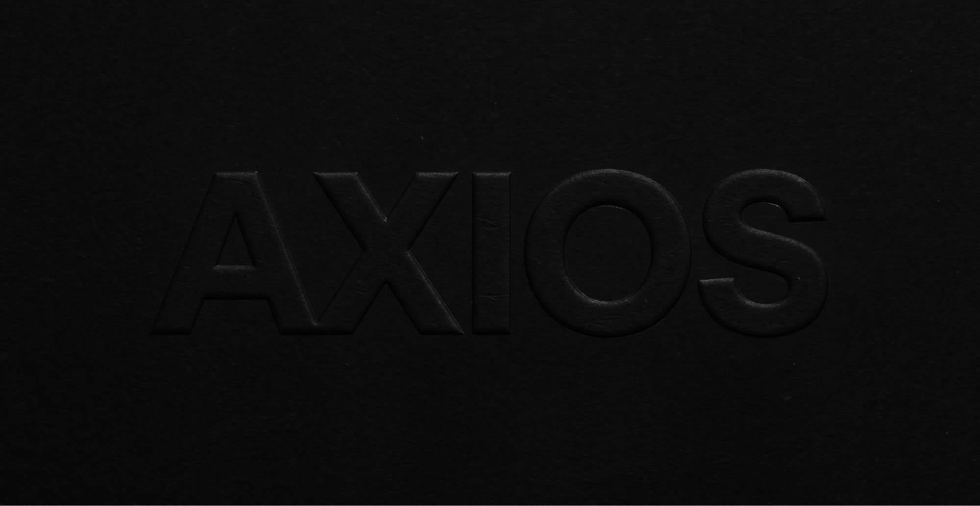 The Axios wordmark blind-embossed into black paper