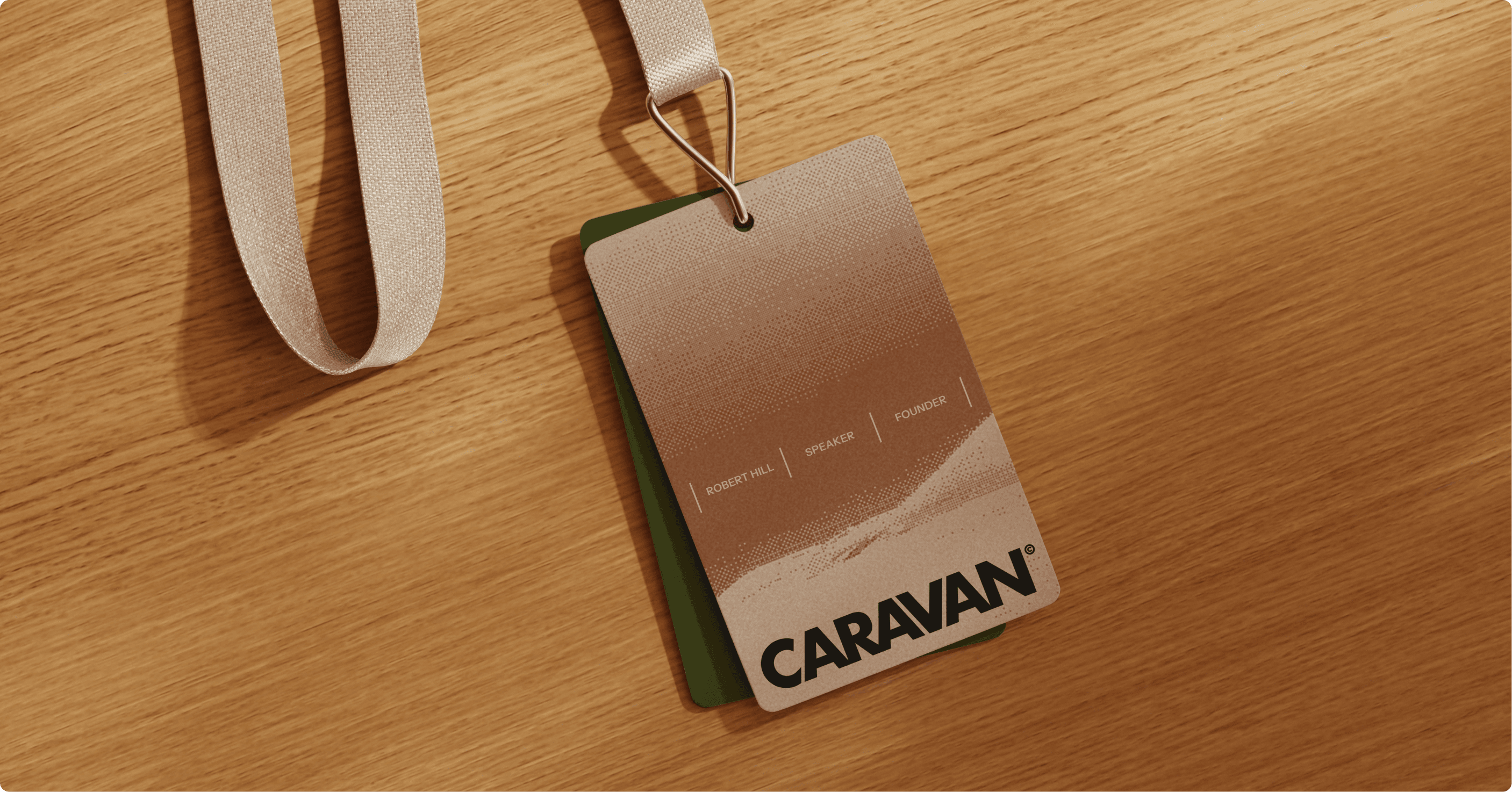 Caravan branded lanyard badge on a wooden desk