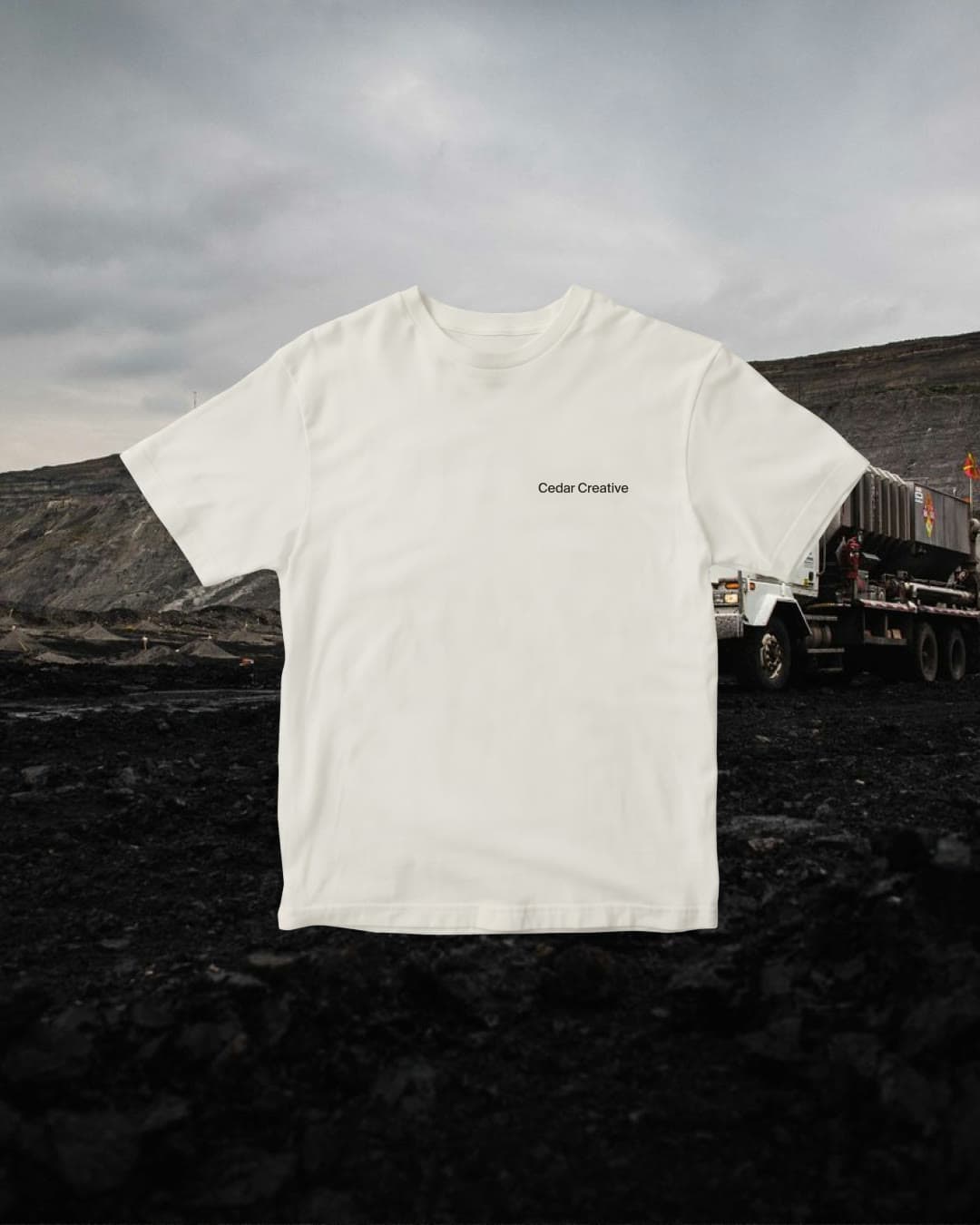 A white Cedar Creative t-shirt over a landscape photograph